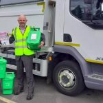man with food waste caddies standing in front of a collection vehicle
