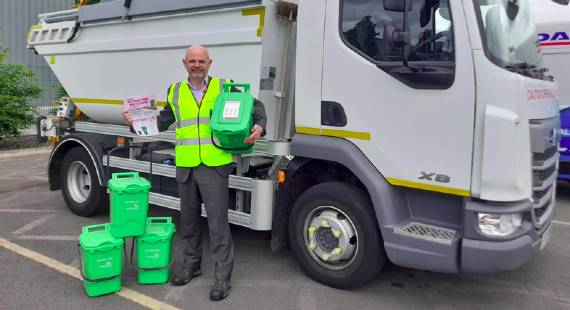 man with food waste caddies standing in front of a collection vehicle